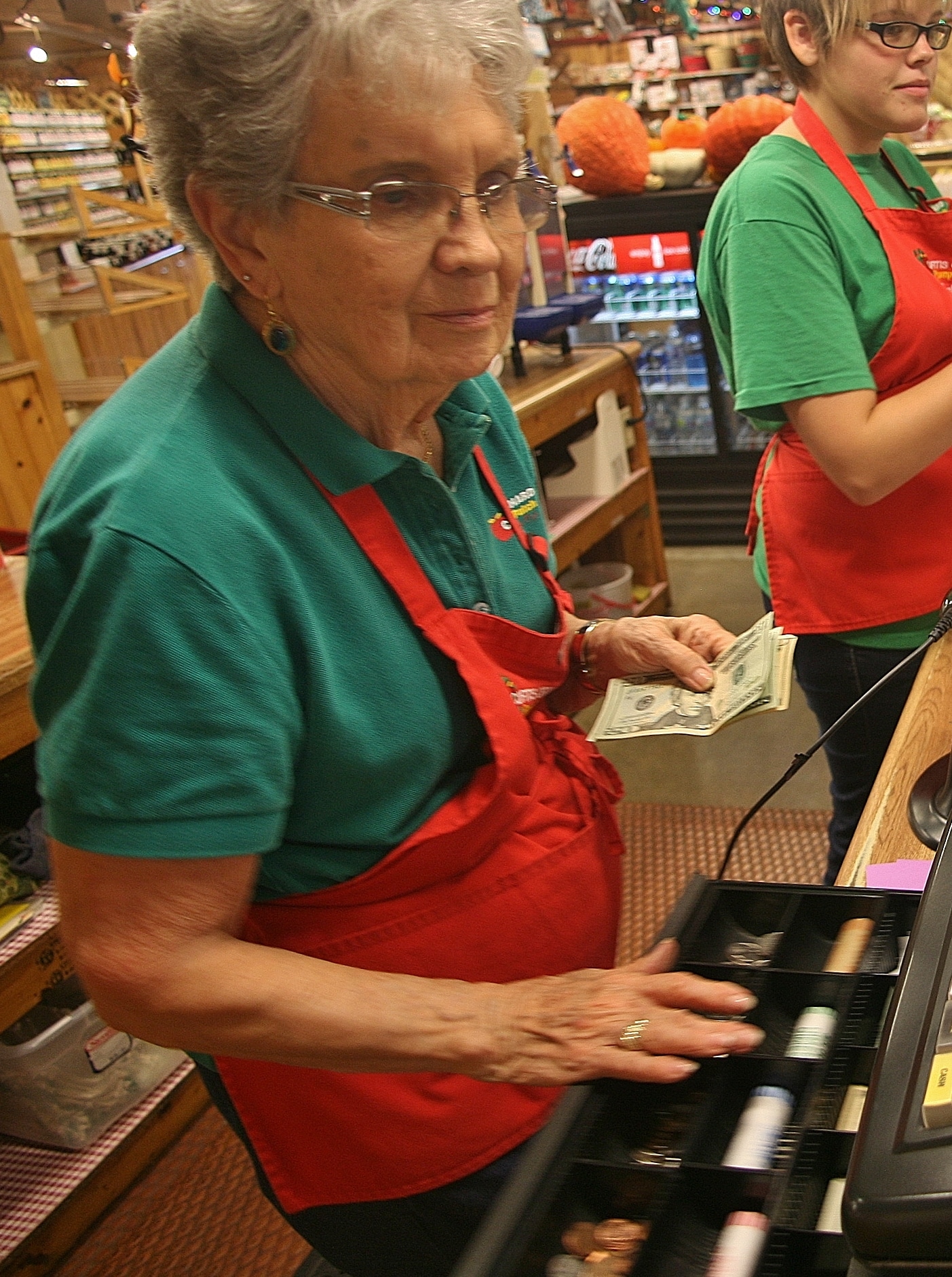 Image of Curtis Orchard Employee grabbing change for customer.