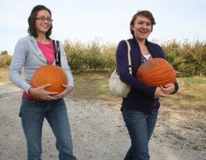 Image of curtis orchard customers holding pumpkins.